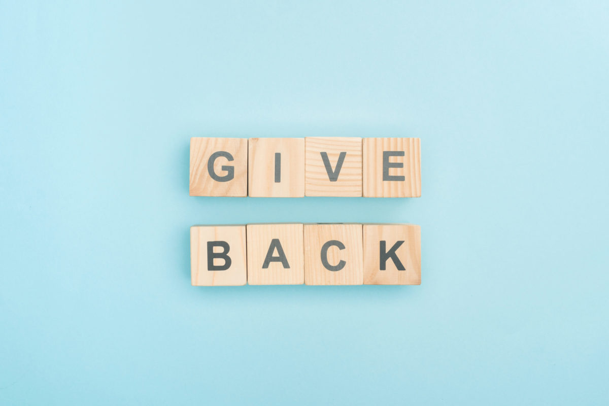 Scrabble letters spelling 'Give Back'