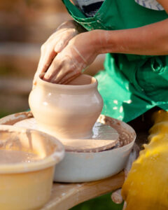 woman's hands forming an item of pottery.