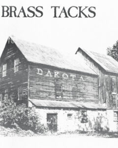 Cover of Brass Tacks Magazine in black and white. Featuring a barn with the letters DAKOTA.