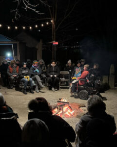 Audience forms a circle around a performer in a wheelchair at the Lowville Festival.